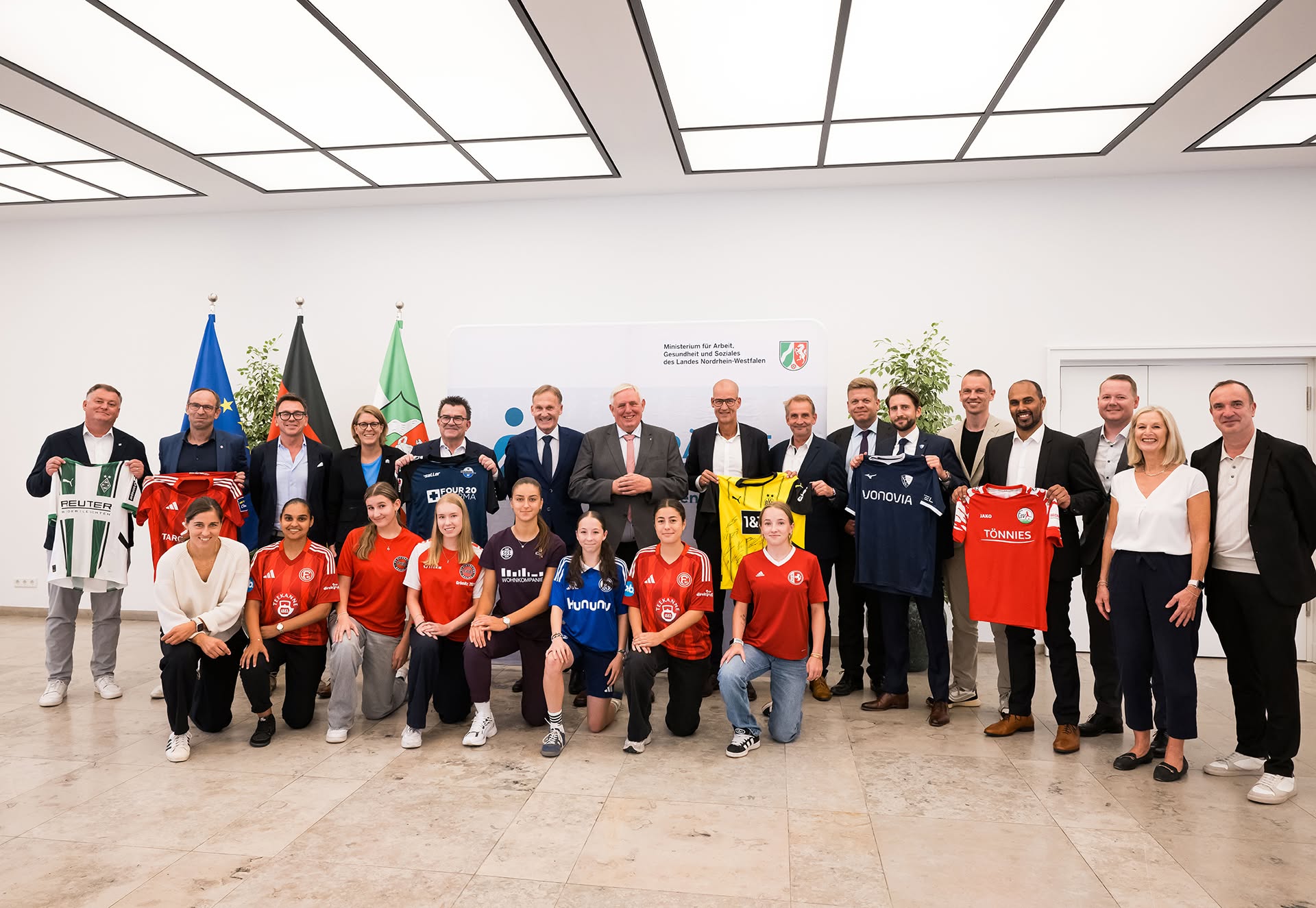 Chris Punnakkattu Daniel with Karl-Josef Laumann, Minister for Labour, Health and Social Affairs of the State of North Rhine-Westphalia, and representatives of the Bundesliga clubs at the kick-off of the "Spielplan Zukunft" alliance at the State Chancellery of NRW in Düsseldorf. (© Andrea Bowinkelmann / MAGS)